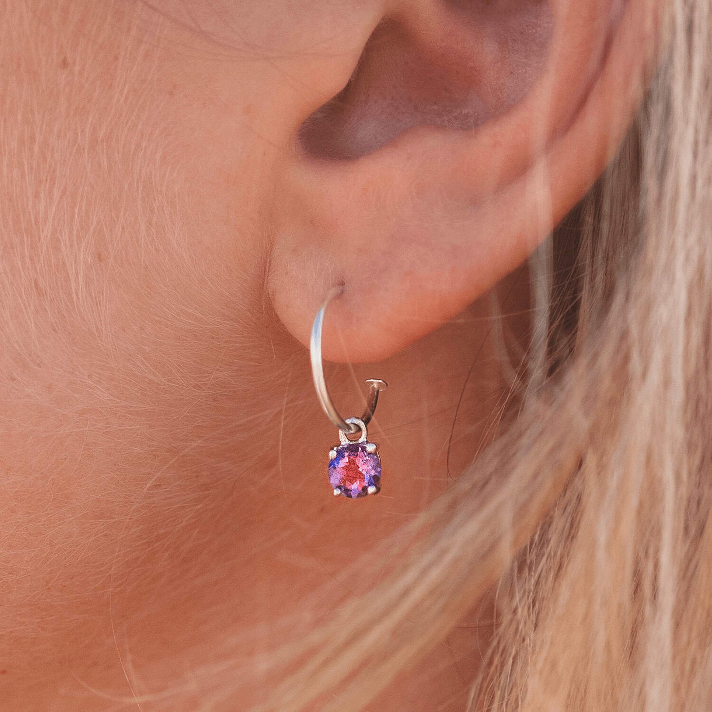 Side view image of a woman wearing Amethyst Dangle Hoop earrings with detachable 5mm round Amethyst gemstones set in four claws.