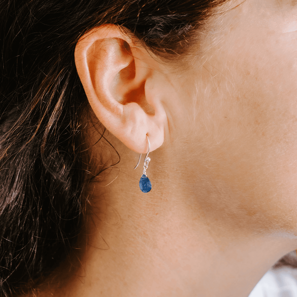 Woman wearing Sterling Silver shepherd’s hook earring with Sapphire drop, side view.