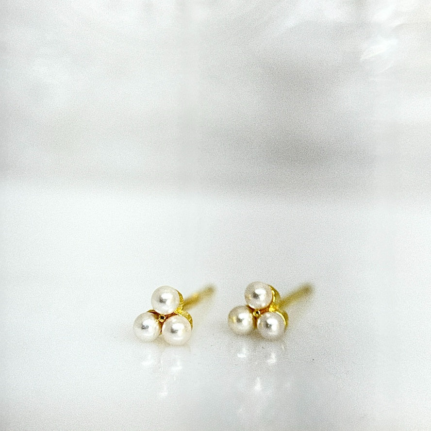 Pair of pearl stud earrings with gold posts on a white background