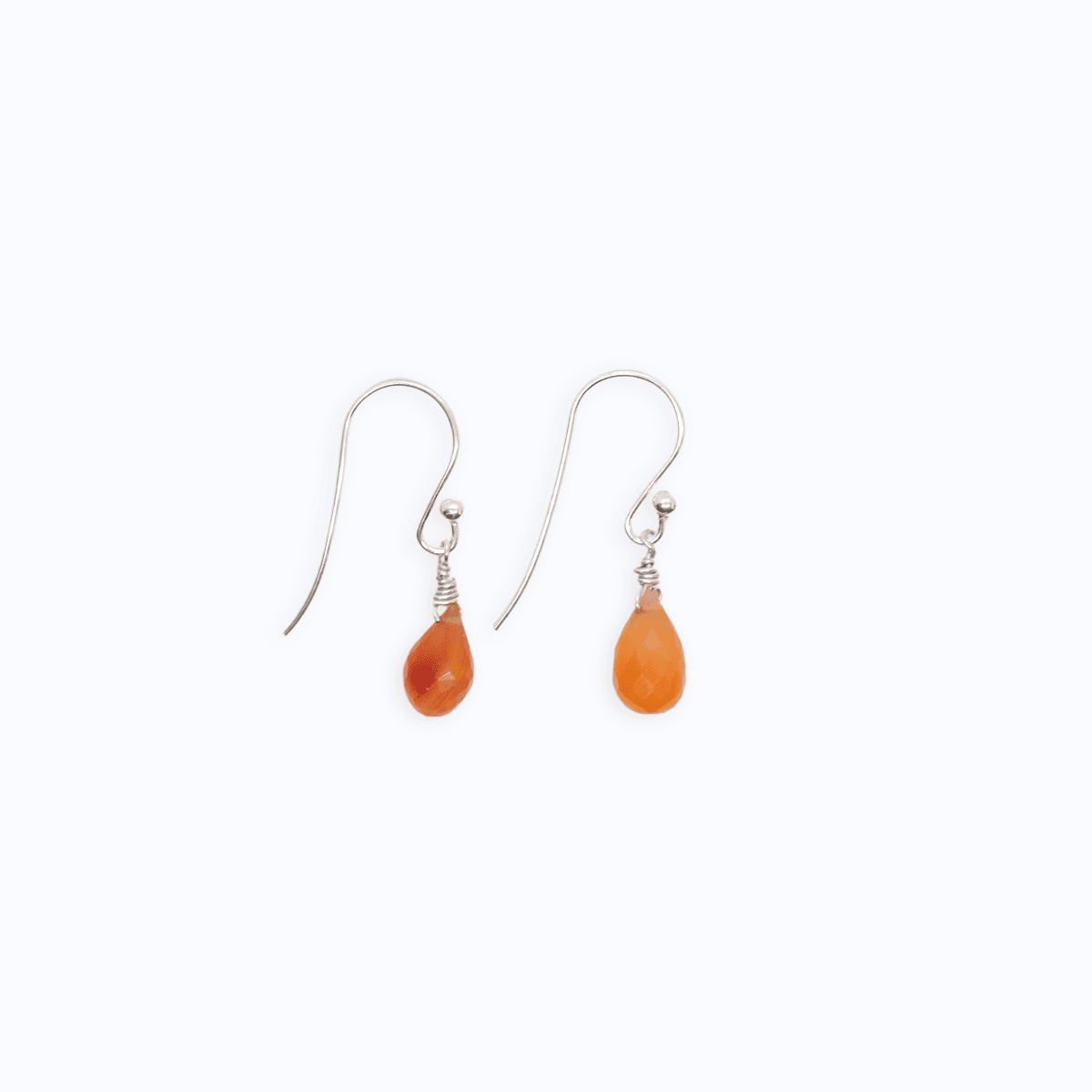 Flat lay view of Sterling Silver shepherd’s hook earrings next to each other with Carnelian drop on white background.