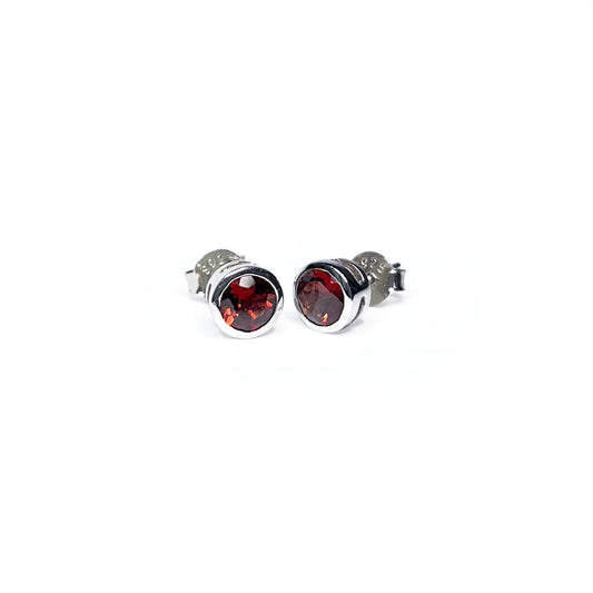 Front view of Garnet Tube Set Stud earrings on a white background. The earrings feature a 5mm round Garnet gemstone set in a Sterling Silver plated tube setting.