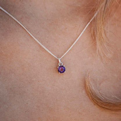 Woman wearing the Amethyst Pendant necklace with a 5mm round Amethyst gemstone set in four claws on a 45cm sterling silver curb chain.