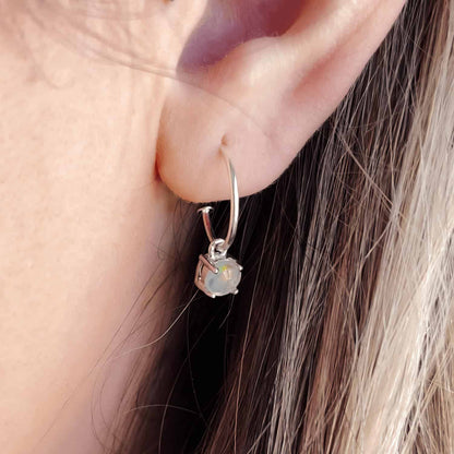 Side view image of a woman wearing Moonstone Dangle Hoop earrings with detachable 5mm round Moonstone gemstones set in four claws.