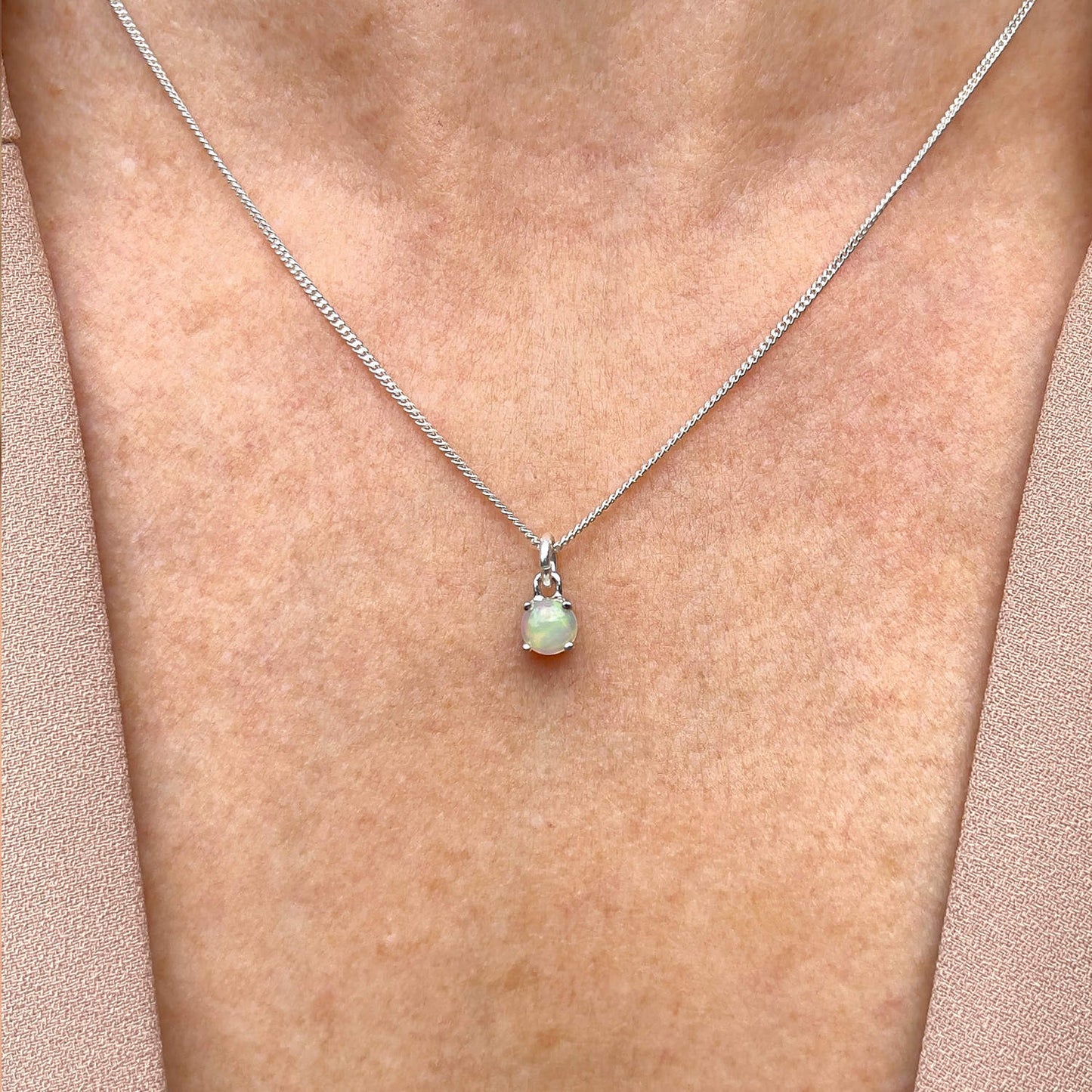 Front view of woman wearing Ethiopian Opal Pendant necklace. Features 5mm round Ethiopian Opal gemstone on 45cm curb chain.