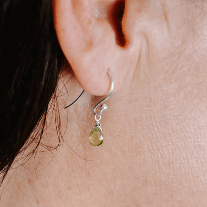 Close up of woman wearing Sterling Silver shepherd’s hook earring with Peridot drop, side view.