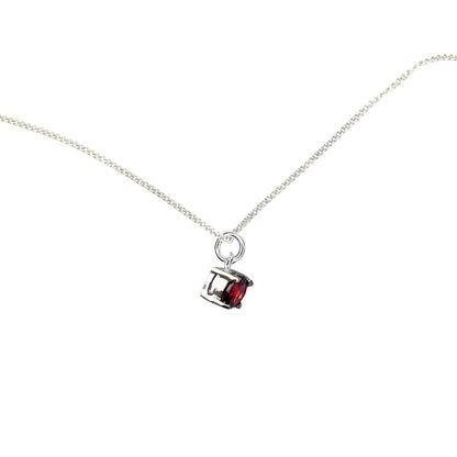 Side view of the Garnet Pendant Sterling Silver necklace on a white background. The necklace features a 5mm round Garnet gemstone set in four claws on a 45cm curb chain.