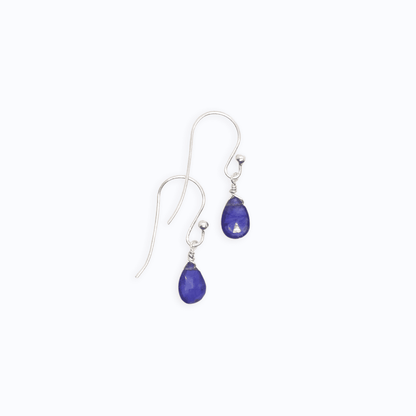 Flat lay view of two Sterling Silver shepherd’s hook earrings with Sapphire drop on white background.