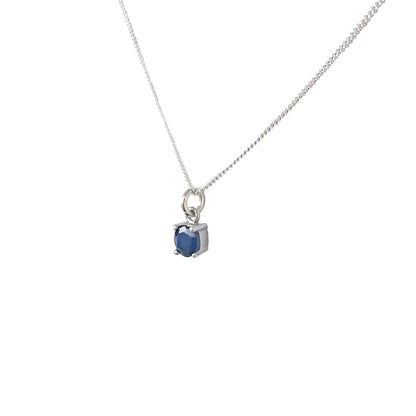 Side view of Sapphire Pendant necklace on white background. 5mm round Sapphire gemstone in four claws on 45cm curb chain.