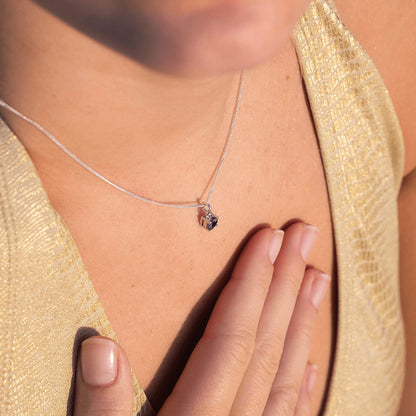 Top view of a woman wearing the Amethyst Pendant necklace, highlighting a 5mm round Amethyst gemstone set in four claws on a 45cm sterling silver curb chain.