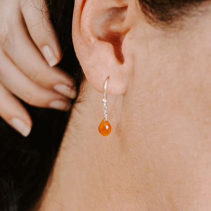 Woman wearing Sterling Silver shepherd’s hook earring with Carnelian drop, side view.