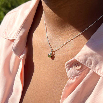 Woman wearing Peridot Pendant necklace, side view. 5mm round Peridot gemstone in four claws on 45cm curb chain.