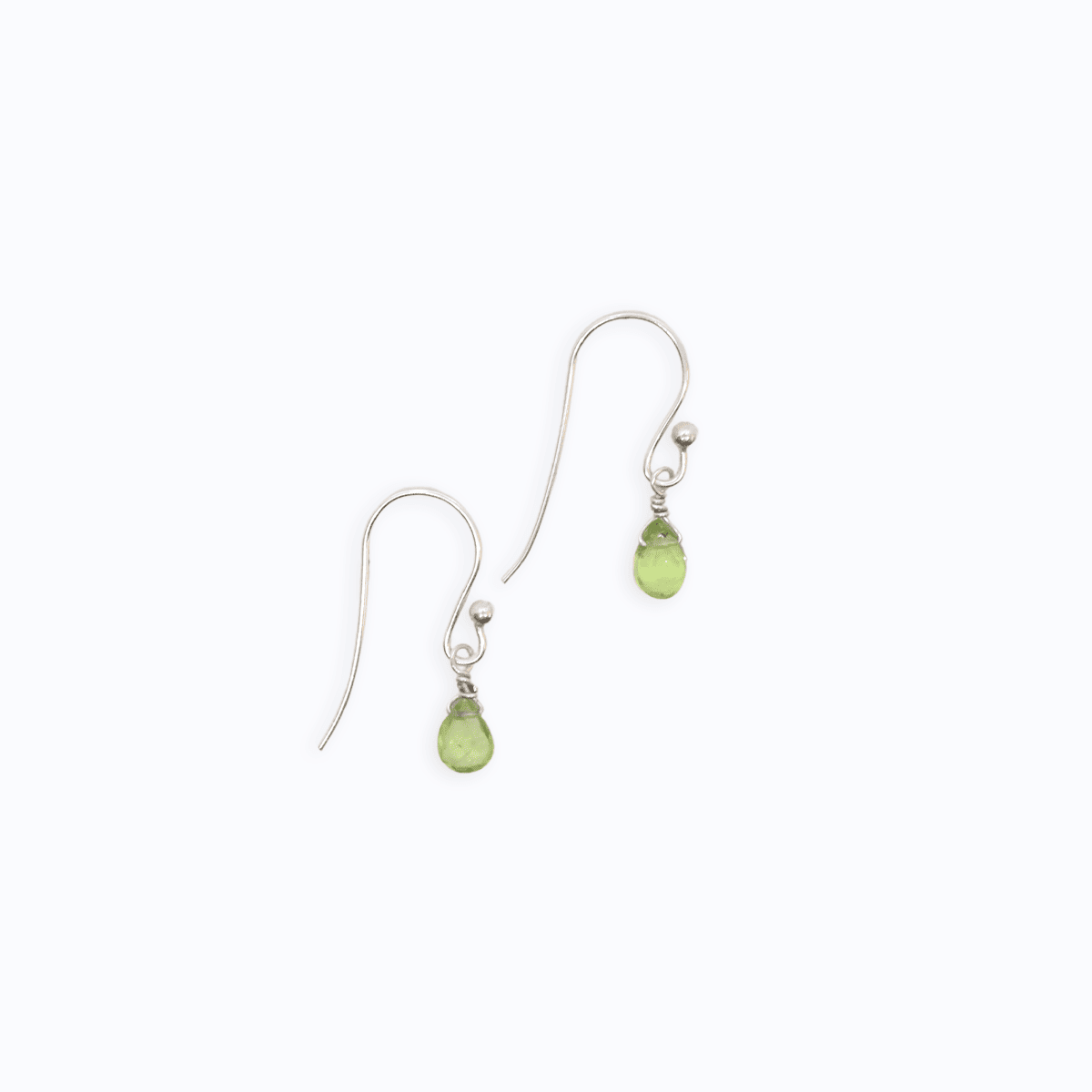 Flat lay view of two Sterling Silver shepherd’s hook earrings with Peridot drop on white background.