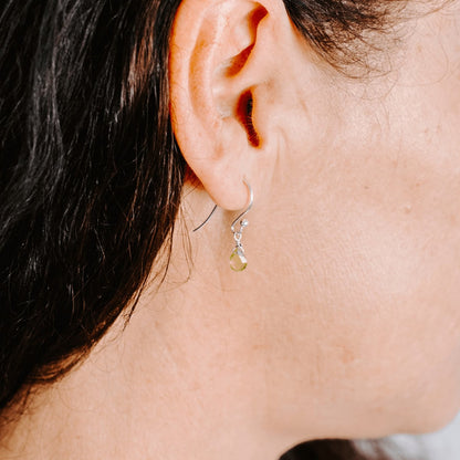 Woman wearing Sterling Silver shepherd’s hook earring with Peridot drop, side view.