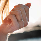 Woman's finger adorned with stacked Ball rings, including yellow and rose gold versions. Versatile Sterling Silver design for any style.