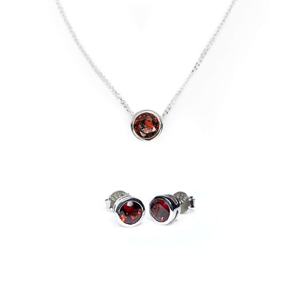 Image of Garnet Tube Set Stud earrings and Slider Necklace on white background. Earrings showcase a 5mm round Garnet gemstone in Sterling Silver tube setting. Necklace displays a 5mm Garnet gemstone set in Sterling Silver tube setting on a 45cm long chain.