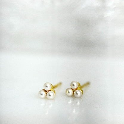 Pair of pearl stud earrings with gold posts on a white background